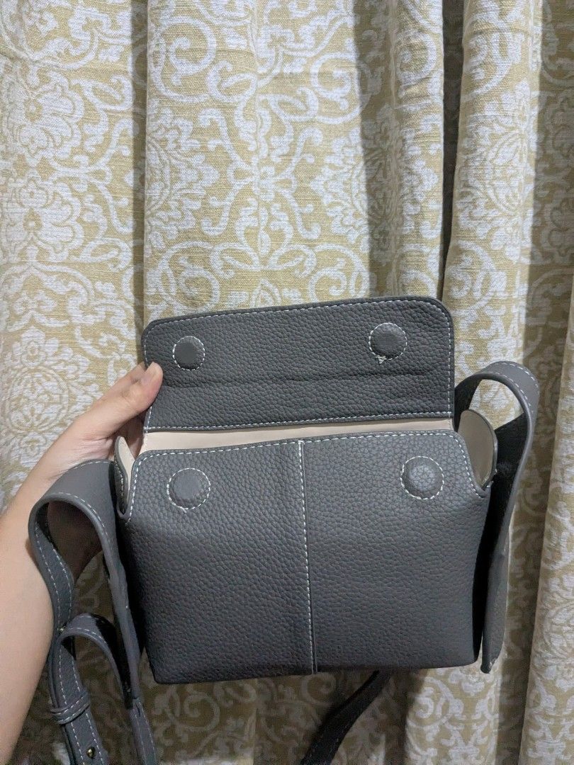 Milan Chiva Crossbody Bag (Category: Shoulder Bags) located in Pandi. Submitted by warmpuppy (Listing ID 1436395868, Image 3). Description: - Milan Chiva crossbody/ shoulder bag - Gray color - Rectangular shape - Flap closure -PU Leather - Long, adjustable strap - Two side pockets - Unique stitching detail on strap.