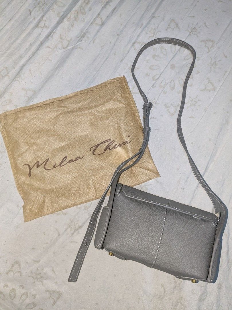 Milan Chiva Crossbody Bag (Category: Shoulder Bags) located in Pandi. Submitted by warmpuppy (Listing ID 1436395868, Image 2). Description: - Milan Chiva crossbody/ shoulder bag - Gray color - Rectangular shape - Flap closure -PU Leather - Long, adjustable strap - Two side pockets - Unique stitching detail on strap.
