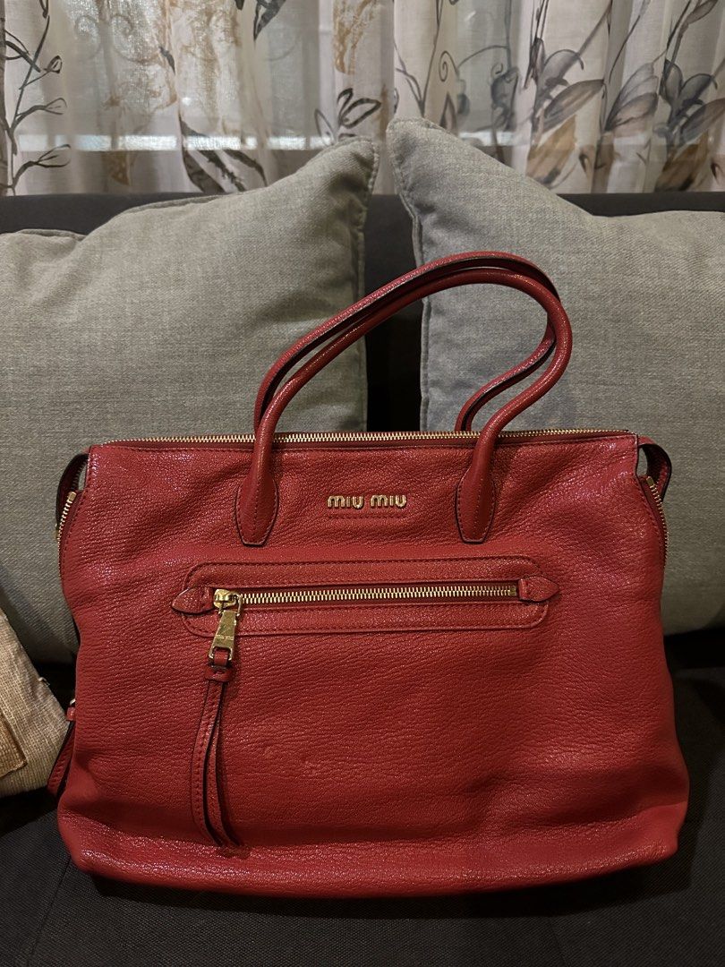 Miu Miu Red Leather Handbag (Category: Luxury Bags & Wallets) located in Manila. Submitted by jerramarieee (Listing ID 1436461997, Image 1). Description: - Authentic Miu Miu handbag - Color: Red - Material: Leather (textured) - Design: Top handle - Closure: Zip - Features: Front zip pocket, detachable shoulder strap - Hardware: Gold-tone - Branding: Miu Miu logo on front • Original Price: Approx. $1,495 (Approx. ₱86,000) • Selling Price: ₱15,000.