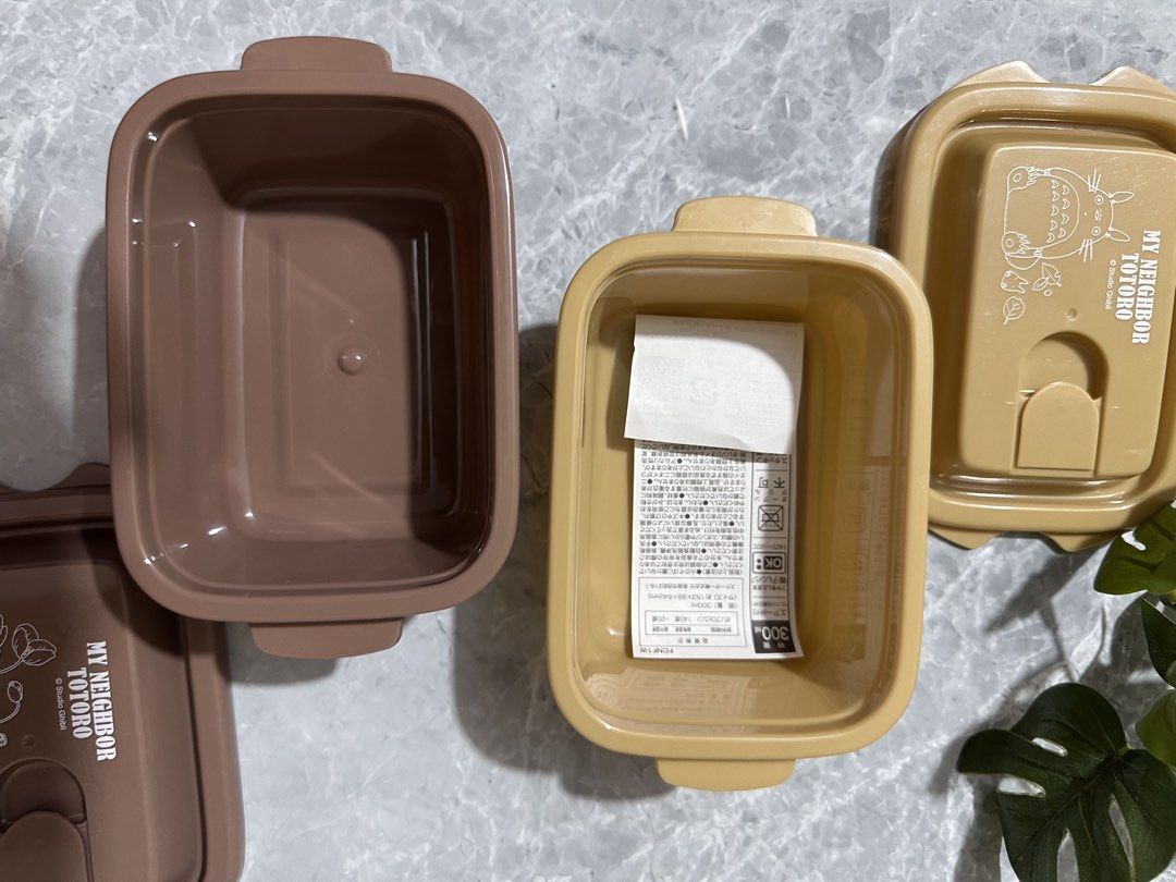 My Neighbor Totoro Lunch Box (Category: Food Organization & Storage) located in Manila. Submitted by mommabearbento2019 (Listing ID 1436322116, Image 2). Description: - My Neighbor Totoro Lunch Box - Available Colors: Beige and Brown - Design: Features Totoro characters and Studio Ghibli logo - Shape: Rectangular - Includes a handle on the lid.