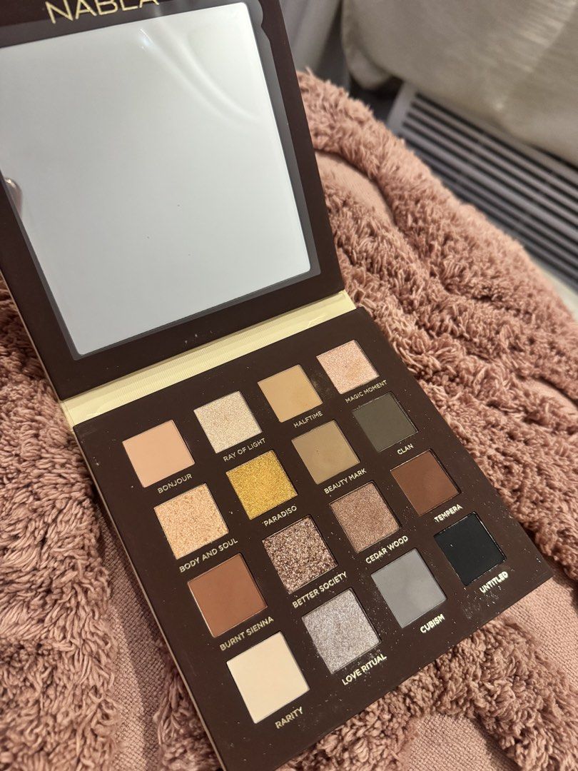 NABLA Side By Side Nude Eyeshadow Palette (Category: Makeup) located in Quezon City. Submitted by aianfrancesca (Listing ID 1436425141, Image 2). Description: - NABLA Side By Side Nude Eyeshadow Palette - Features a range of neutral eyeshadow shades - Includes matte and shimmer finishes - Shades include: Bonjour, Ray of Light, Magic Moment - Comes with a built-in mirror - Light beige packaging with NABLA logo -bought for 3500+ -rfs too much eyesh