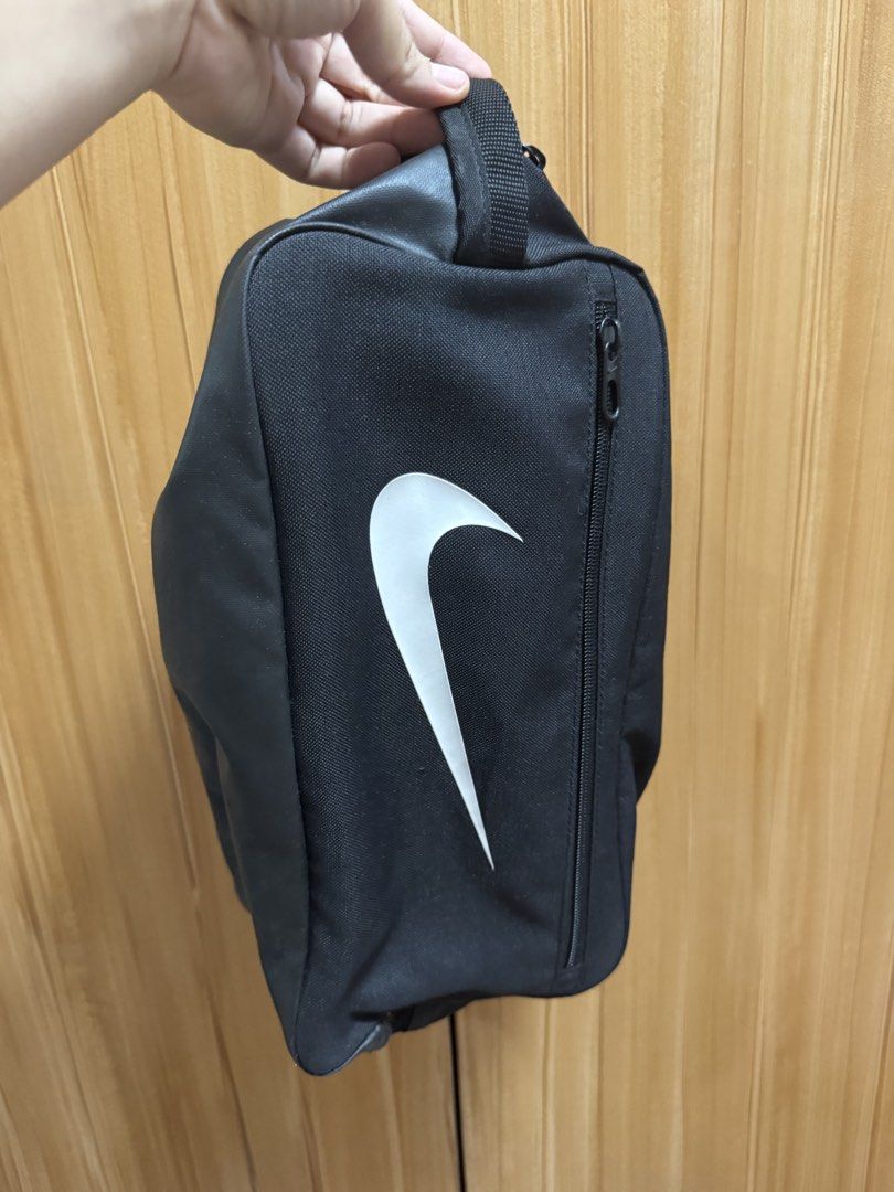Nike Shoe Bag (Category: Belt bags, Clutches and Pouches) located in Manila. Submitted by prelovedshop0818 (Listing ID 1436388321, Image 1). Description: - Black Nike shoe bag - White Nike swoosh logo - Zippered closure - Carrying handle - Made of durable fabric - Designed to carry and protect shoes - Compact and easy to carry.