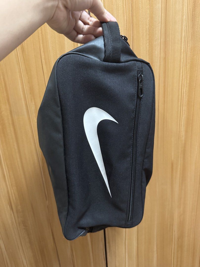 Nike Shoe Bag (Category: Belt bags, Clutches and Pouches) located in Manila. Submitted by prelovedshop0818 (Listing ID 1436388321, Image 2). Description: - Black Nike shoe bag - White Nike swoosh logo - Zippered closure - Carrying handle - Made of durable fabric - Designed to carry and protect shoes - Compact and easy to carry.