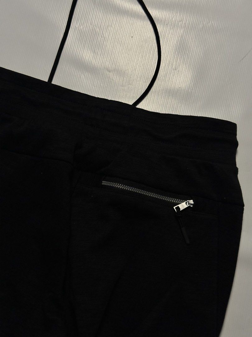 Nike Tech Fleece Jogger Pants Black (Category: Joggers) located in Manila. Submitted by johnedel_james (Listing ID 1436432722, Image 3). Description: - Nike Tech Fleece joggers - Color: Black - Size: M - Features: Drawstring waistband, Nike logo, zippered back pocket - Model: SP190710TWC - Material: Cotton/Polyester blend - Textured appearance.