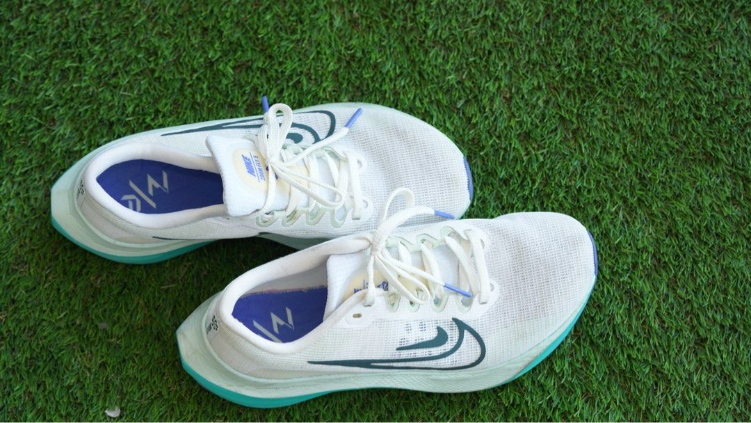Nike Zoom Fly 5 Running Shoes (Category: Sneakers) located in San Juan City. Submitted by saristoreonline (Listing ID 1436402917, Image 2). Description: Nike Zoom Fly 5 running shoes in white and teal. Features a teal midsole with a purple outsole. The Nike swoosh logo is visible on the side. The shoes have white laces with teal tips. The insole has a design with the Nike logo. The shoes are on a green surface..
