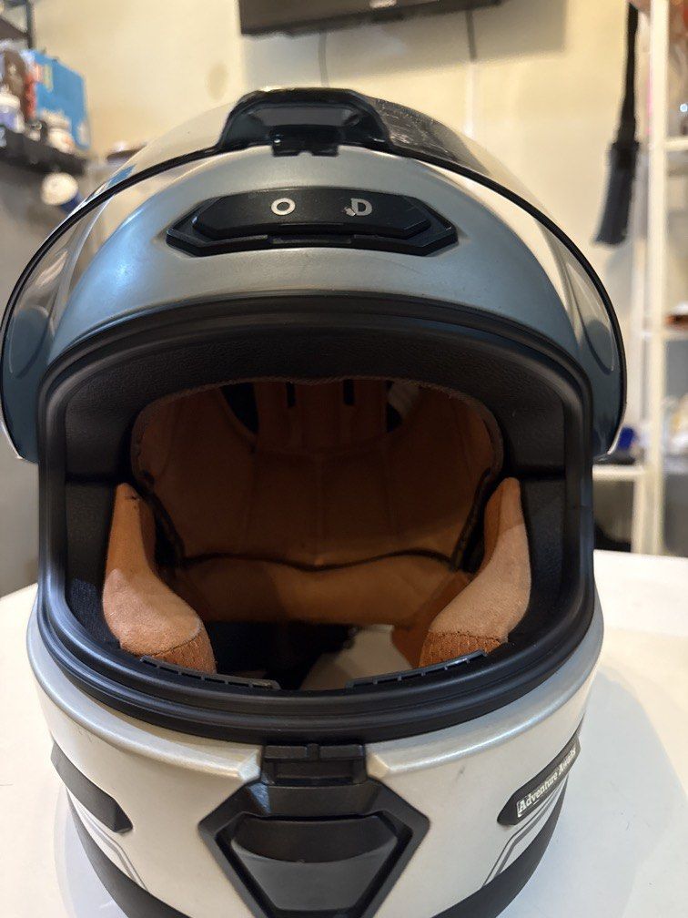 Nomad Camino Motorcycle Helmet (Category: Helmets and other Riding Gears) located in Cainta. Submitted by angelesasdfghjkl13 (Listing ID 1436422884, Image 2). Description: - Nomad Camino motorcycle helmet - Size: L (59-60) - Color: Silver exterior with black visor - DOT certified - Interior padding visible - Features "Adventure Awaits" print on the front “Kaka-ceramiclang” .