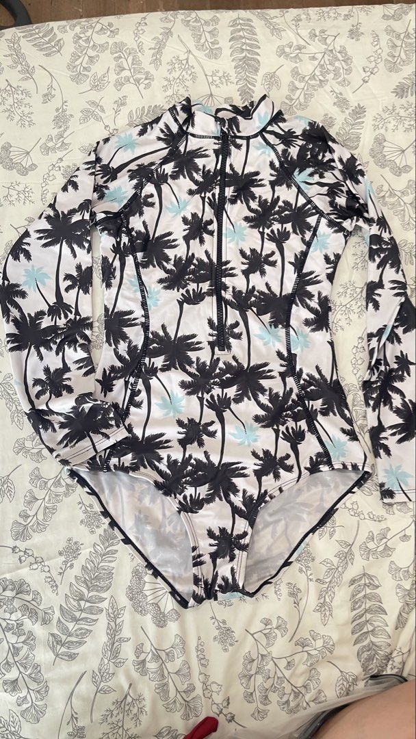 Palm Tree Print Long Sleeve Swimsuit (Category: Bikinis & Swimsuits) located in Quezon City. Submitted by declutterrgirlyy (Listing ID 1436338377, Image 1). Description: - Long-sleeved swimsuit - Vibrant palm tree print - Front zipper - Flattering silhouette - White base with black palm tree pattern - Light blue accents - Perfect for beach days and pool parties.
