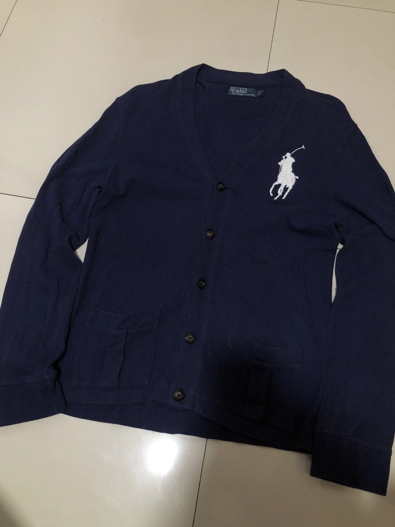 Polo Ralph Lauren Navy Cardigan (Category: Coats, Jackets and Outerwear) located in Manila. Submitted by yocsthrifted (Listing ID 1436308076, Image 2). Description: - Polo Ralph Lauren navy cardigan - Features a large white polo player logo - V-neck and button closure - Two front pockets - Button details on sleeves - Minor stains on sleeves - Size tag visible in photos.