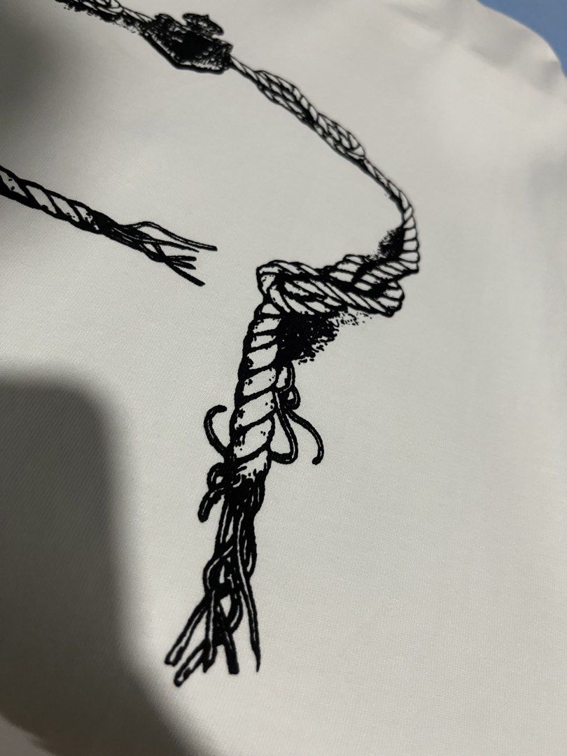 Prada Milano Rope Graphic T-shirt (Category: Tshirts & Polo Shirts ) located in Maasin. Submitted by niconii090 (Listing ID 1436297366, Image 3). Description: - Prada Milano T-shirt - Color: White - Graphic: Black rope design - ✅ 9.5/10 condition 📏20x25(inches) - Features: Crew neck, short sleeves - Condition: Excellent - Authentic Prada.