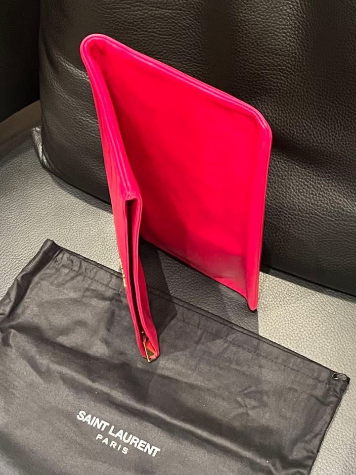 Saint Laurent Clutch in Hot Pink (Category: Luxury Bags & Wallets) located in Makati City. Submitted by aiahscloset (Listing ID 1436412817, Image 2). Description: - Authentic Saint Laurent clutch - Bright pink leather - Gold-colored Saint Laurent logo - Includes dust bag - Rectangular shape, fold-over style - Interior matches exterior color.