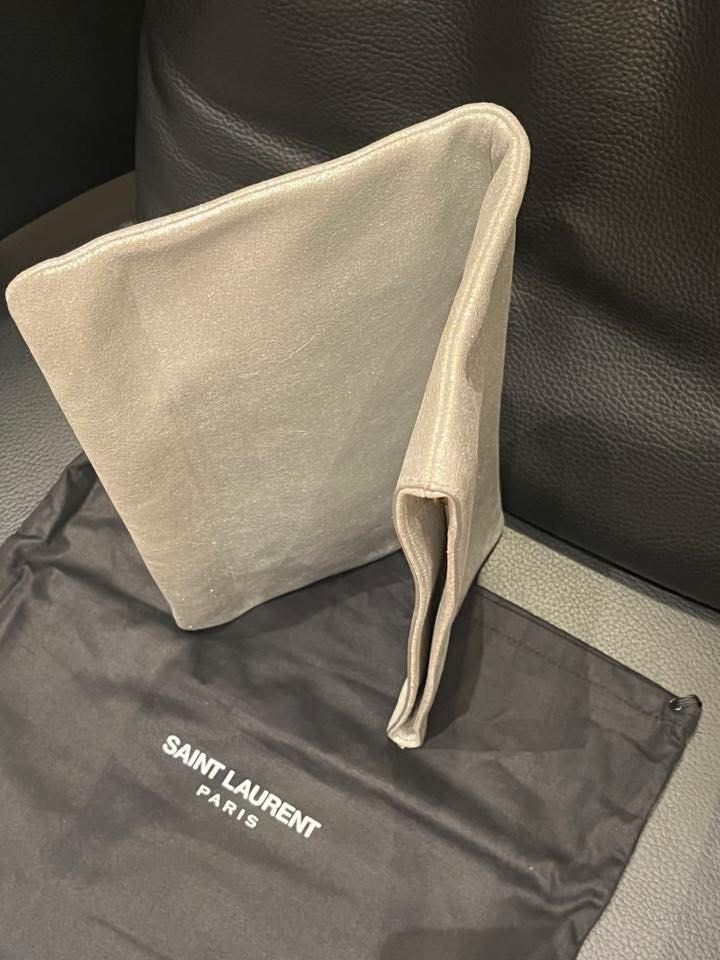 Saint Laurent Metallic Clutch (Category: Luxury Bags & Wallets) located in Makati City. Submitted by aiahscloset (Listing ID 1436412031, Image 3). Description: - Saint Laurent clutch - Metallic finish - Fold-over style - Gold Saint Laurent logo - Includes dust bag - Clean interior and exterior - Perfect for special occasions.