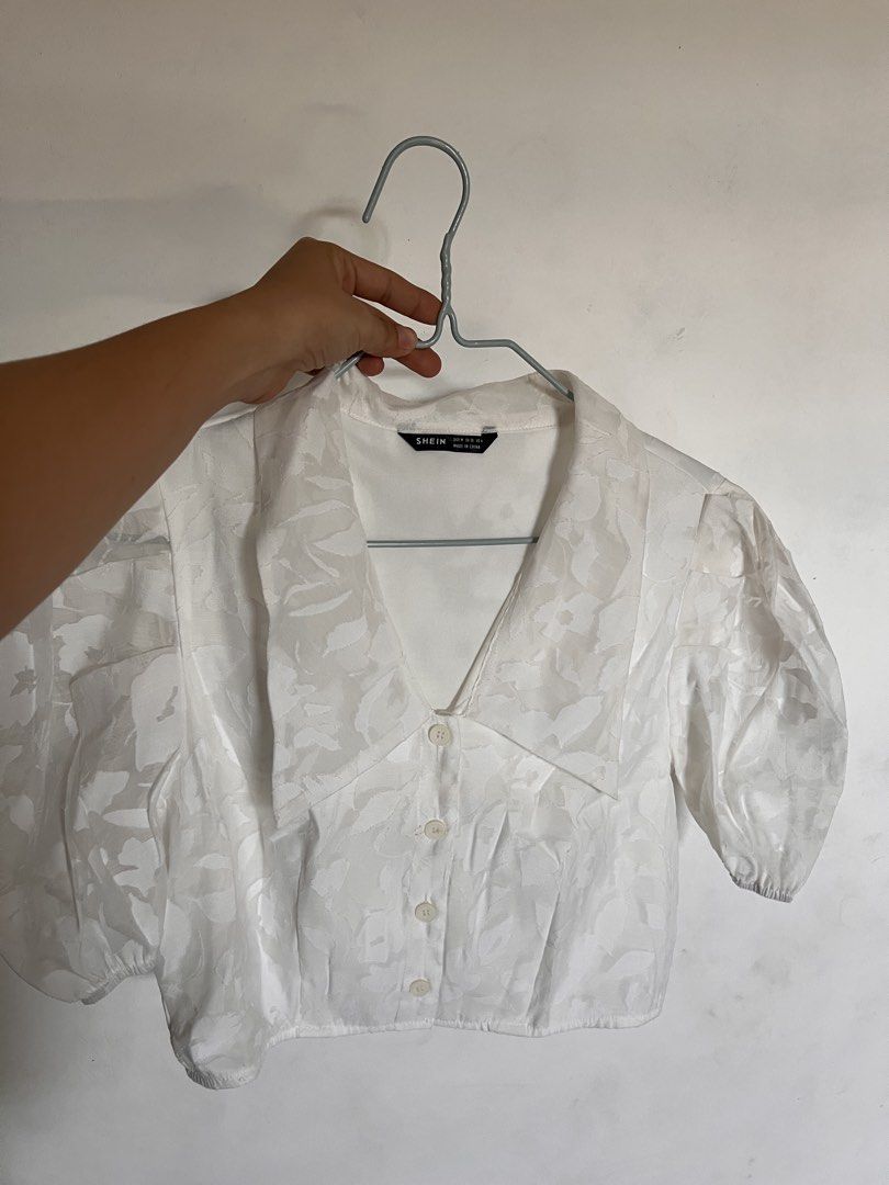 SHEIN White puff Floral Top (Category: Blouses) located in Concepcion. Submitted by clodiiiee2777 (Listing ID 1436298994, Image 1). Description: - SHEIN white floral top - Size: M - Features a collared neckline - Button-down front - Short puff sleeves - Made in China -unworn.