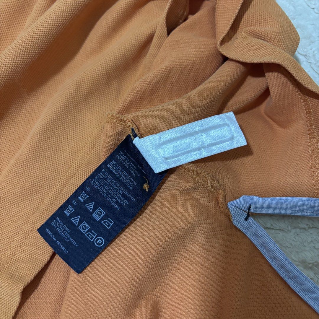 Tommy Hilfiger Orange Polo Shirt (Category: Tshirts & Polo Shirts ) located in Quezon City. Submitted by grailph (Listing ID 1436408468, Image 3). Description: - Orange Tommy Hilfiger polo shirt - Classic polo collar with blue lining - Small on tag - Dimensions 20”x29”-31” - Small embroidered logo on chest - Three-button placket - Short sleeves - Straight hem - Made of cotton Color rate 8/10 Issue last 2 pics.