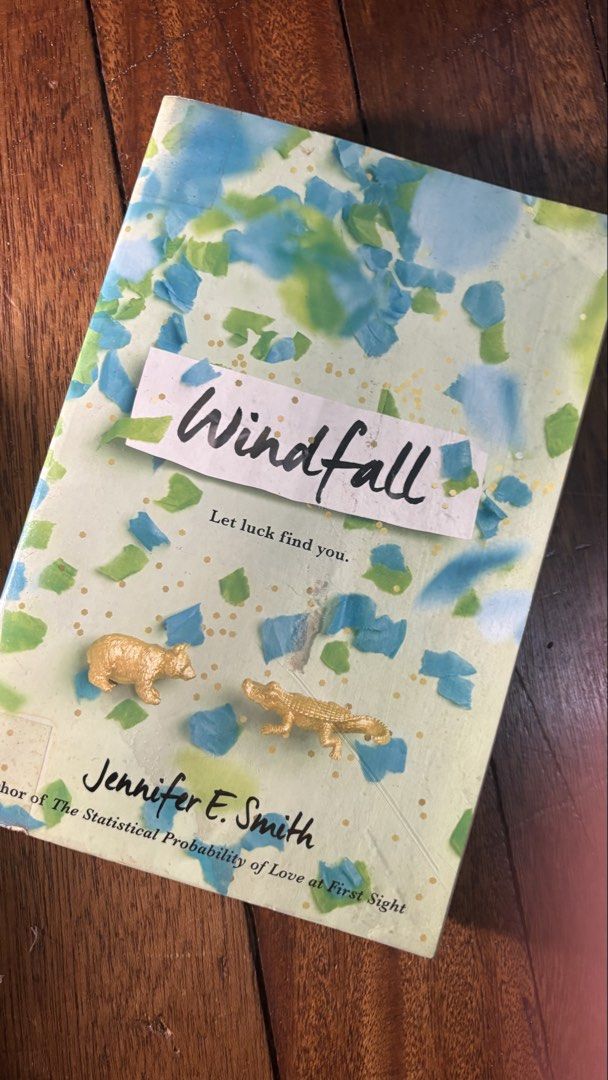 Windfall by Jennifer E. Smith (Category: Storybooks) located in Mandaluyong City. Submitted by zealeagle_c4f5d1 (Listing ID 1436382040, Image 1). Description: - Book Title: Windfall - Author: Jennifer E. Smith - Cover: Light green background with blue and white accents. - Cover Details: Features two small gold-colored animal figurines. - Tagline: "Let luck find you.".