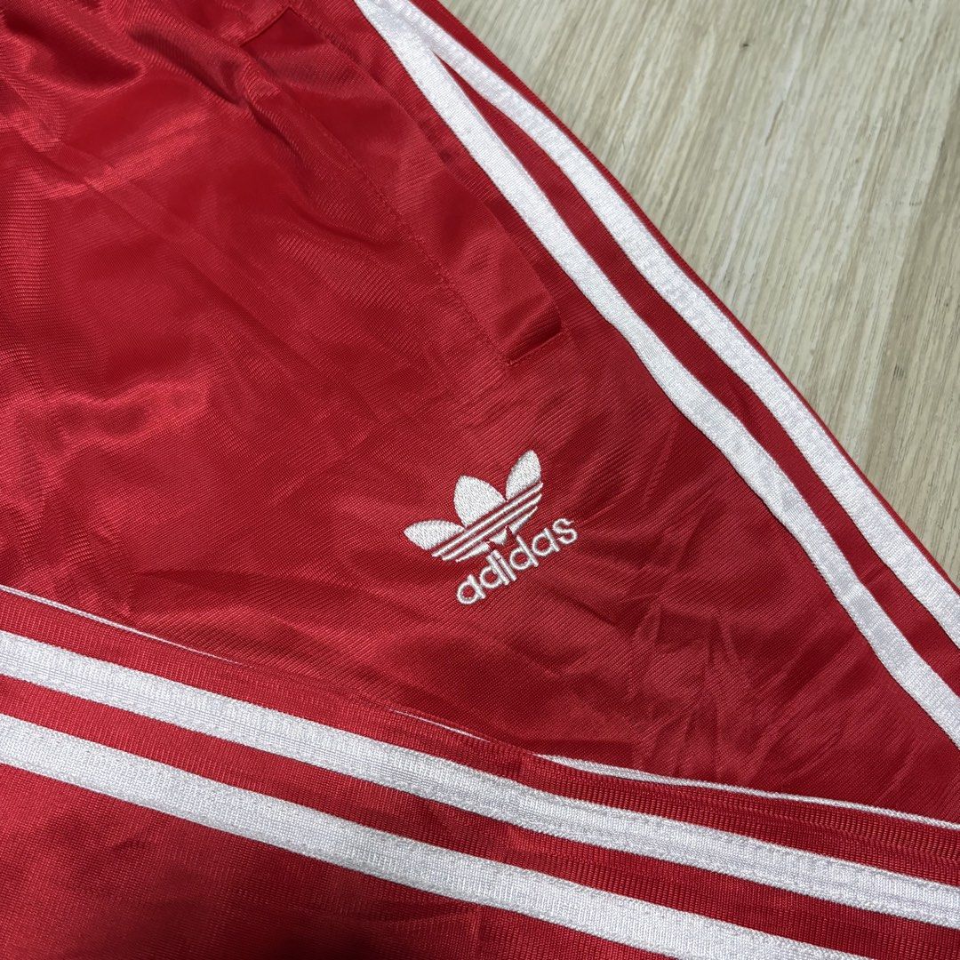 Adidas Red Track Pants with White Stripes (Category: Other Bottoms) located in Rizal. Submitted by thriftdrip.402 (Listing ID 1436605133, Image 2). Description: - Adidas track pants in red - White stripes on sides - Adidas trefoil logo - Elastic waistband - Satin-like fabric - Perfect for a sporty look - 25-32 Waist - 38 Length - 8 Leg Hole.