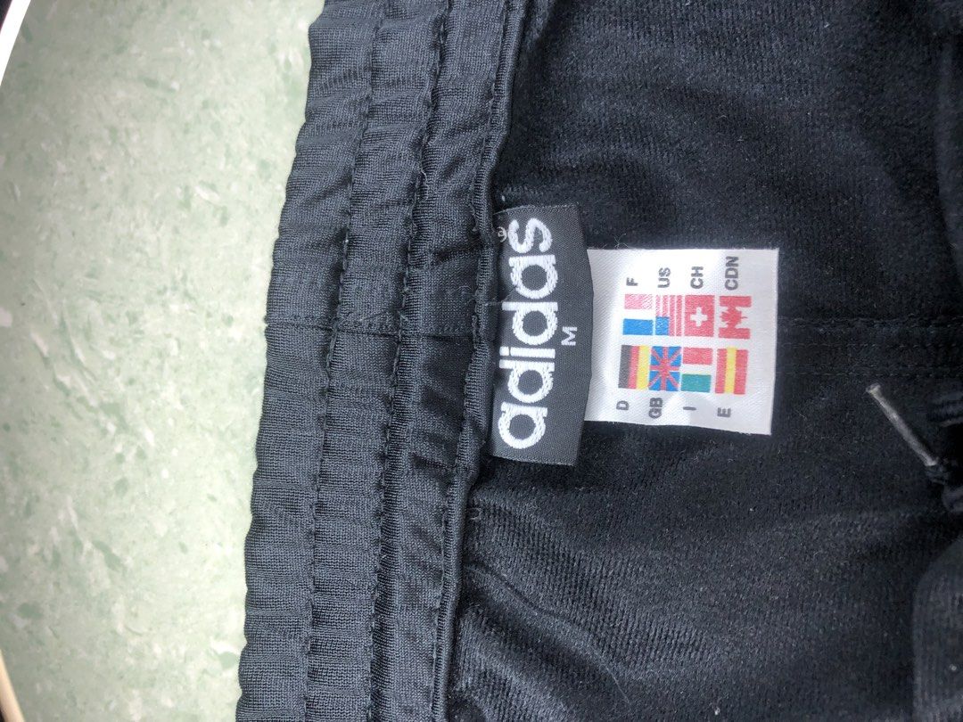 Adidas Track Pants - Black with White Stripes (Category: Activewear) located in Midsayap. Submitted by karldonor01258 (Listing ID 1436499928, Image 2). Description: Classic Adidas track pants in black with white stripes. Features the Adidas logo on the leg and a size M tag. Includes a drawstring waist and side pockets. There is a small hole on the back of the pants. Perfect for casual wear or workouts. -Dimes:W38 L42 -leg hole:8.
