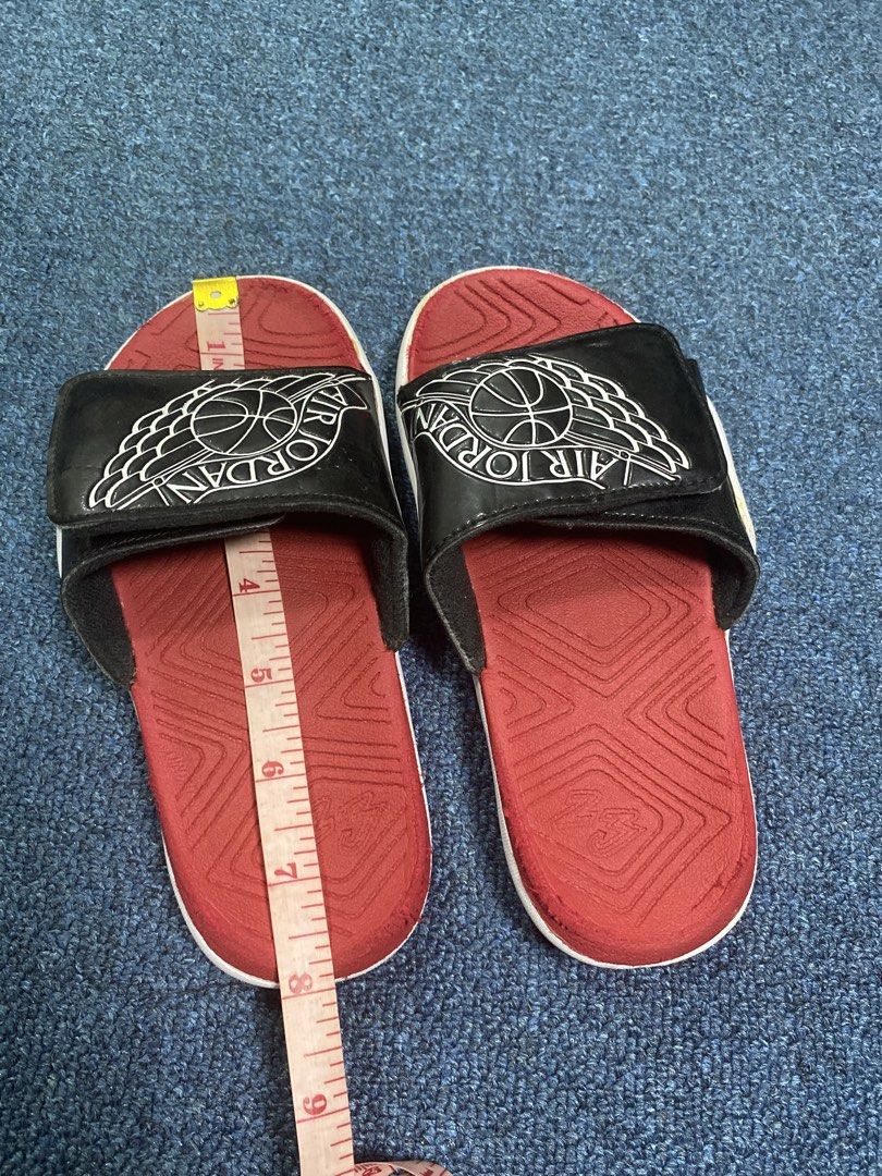 Air Jordan Slides - Size 12C (Category: Slippers & Slides) located in Manila. Submitted by Thrifings (Listing ID 1436526160, Image 3). Description: - Air Jordan slides - Color: Black, red, and white - Size: 12C - Features the Air Jordan logo - Red footbed, white sole.