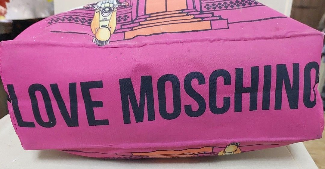 Authentic Love Moschino Pink Tote Bag FREE if you buy any of my items (Category: Tote Bags) located in Quezon City. Submitted by gachrie (Listing ID 1436592696, Image 3). Description: - Authentic Love Moschino tote bag - Eye-catching pink exterior with unique graphic but with signs of uae and bubbles. some very tiny white spots of paint on one side and one handle because it was not properly stored during our house renovation - Chain and leather h