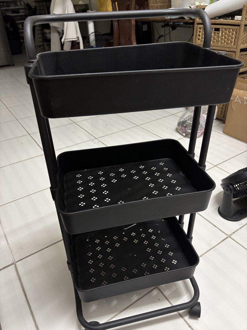 Black 3-Tier Rolling Cart (Category: Other Home Furniture) located in Del Monte. Submitted by syjamie22 (Listing ID 1436601150, Image 2). Description: - Black rolling cart - 3-tier design for storage - Includes a handle for easy maneuverability - Equipped with wheels for mobility - Ideal for organizing items in your home or office - Trays feature a perforated design - Constructed from metal and plastic.
