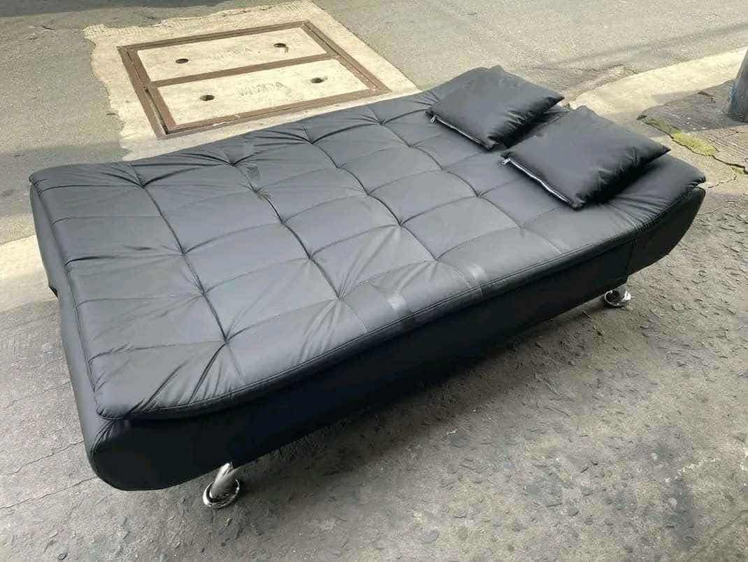 Black Leather Sofa Bed with Pillows (Category: Sofas) located in Manila. Submitted by lykcacamacho (Listing ID 1436642862, Image 2). Description: - Stylish black leather sofa bed - Features a tufted design - Includes two matching pillows - Chrome legs - Folds down into a bed - Perfect for small spaces or guest rooms.