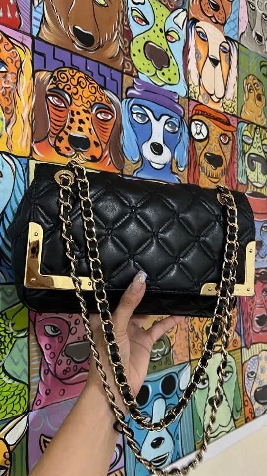 Black Quilted Shoulder Bag with Gold Accents (Category: Shoulder Bags) located in Makati City. Submitted by aiahscloset (Listing ID 1436629162, Image 2). Description: - Black quilted shoulder bag - Gold-toned chain straps - Gold accents - Smooth, leather-like material - Rectangular shape with flap closure - Suitable for everyday or special occasions.