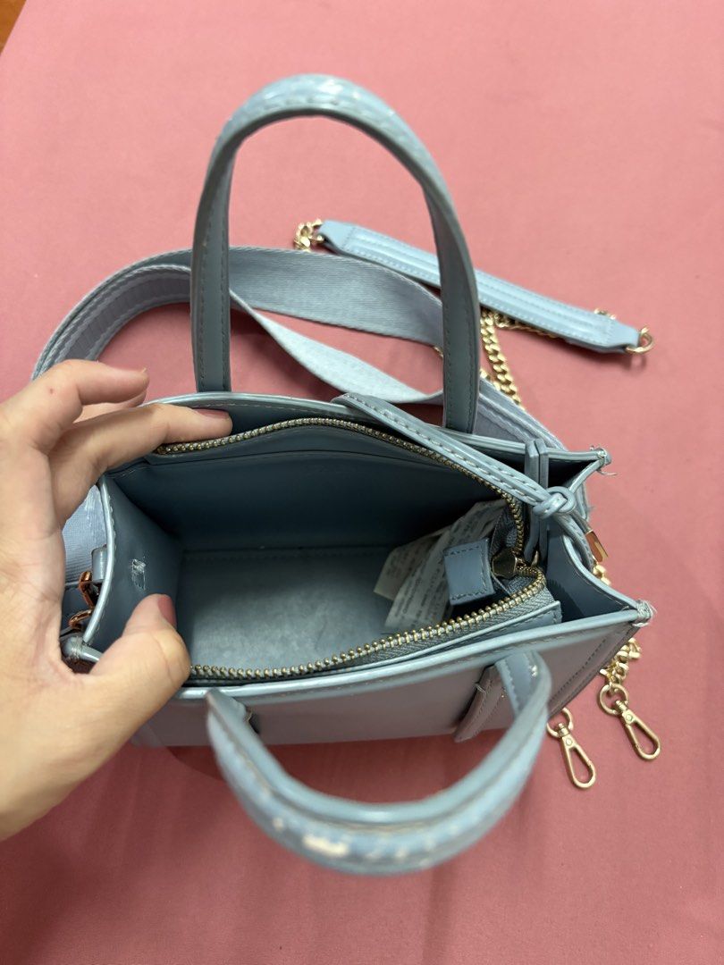 Blue Mini Tote Bag with Interchangeable Strap/Gold Chain (Category: Tote Bags) located in Manila. Submitted by closetsofaddie (Listing ID 1436581367, Image 3). Description: - Light blue mini tote bag - Gold-colored hardware - Detachable shoulder strap included - Features a gold chain strap - Top handle for carrying - Zippered main compartment - Clean interior - Minor wear on top handle - Color may vary due to lighting 💳Mode of Payment: 💙 GCash 