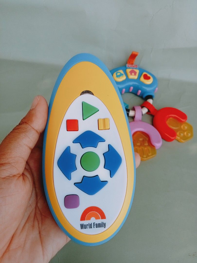 Fisher-Price and World Family Baby Toy (Category: Toys & Games) located in Rosario. Submitted by elysedeclutter (Listing ID 1436475148, Image 2). Description: - Fisher-Price baby toy designed for babies and toddlers. - Includes a remote control with colorful, shaped buttons. - Comes with a set of keys in different colors and shapes. - Features a convenient loop for easy carrying..