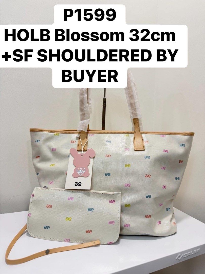 HOLB Blossom 32cm Tote Bag (Category: Tote Bags) located in San Fernando. Submitted by leonag (Listing ID 1436643417, Image 1). Description: HOLB Blossom tote bag with a matching pouch. Features a cream-colored exterior with a pattern of colorful bows. The bag has a 32cm size. Includes a detachable strap for the pouch. Shipping fee is shouldered by the buyer..