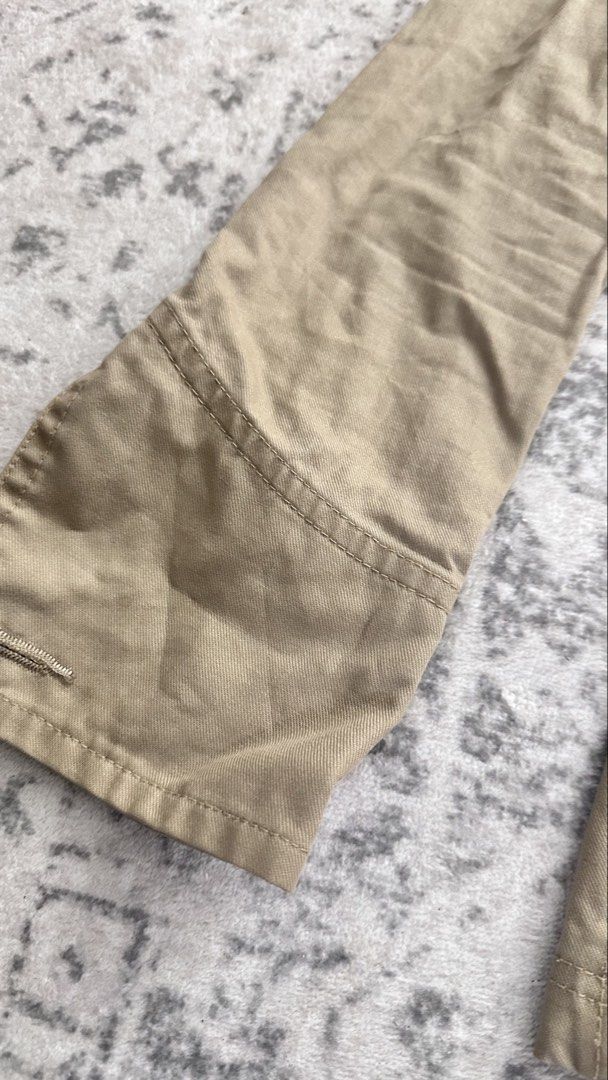 jacket (Category: Other Tops) located in Sungai Buloh. Submitted by frangipanithrift (Listing ID 1436514770, Image 3). Description: casual utility or safari-style jacket with a tailored, feminine fit. • A classic khaki/beige color in a durable cotton twill or chino fabric with a slight diagonal weave. • A full-length button-down front featuring large, round tortoise-shell or tan-colored buttons. • Features a classic, pointed fold-over collar. • T