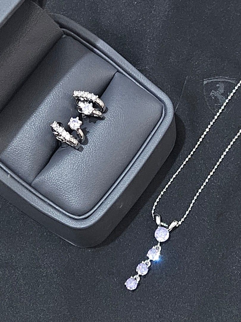 Lavender Cubic Earrings & Choker Necklace (Category: Necklaces) located in Muntinlupa City. Submitted by a.mnl (Listing ID 1436569717, Image 1). Description: - Silver jewelry set - Necklace with dangling purple stones - Matching earrings with unique design - Includes a black jewelry box - Perfect for any outfit From Hokkaido Japan .