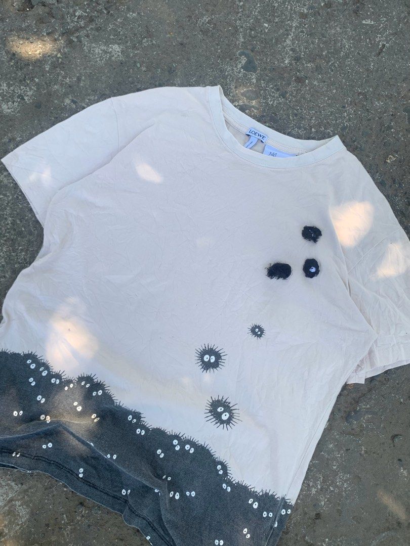 Loewe x Spirited Away T-shirt (Category: Tshirts & Polo Shirts ) located in Manila. Submitted by hiddenthrift_co (Listing ID 1436521874, Image 2). Description: - Loewe T-shirt with a Spirited Away-inspired design. - Features a light-colored upper section with black soot sprites. - Dark gray lower section with white eyes. - Classic crew neck and short sleeves. - Includes the Loewe logo on the collar..