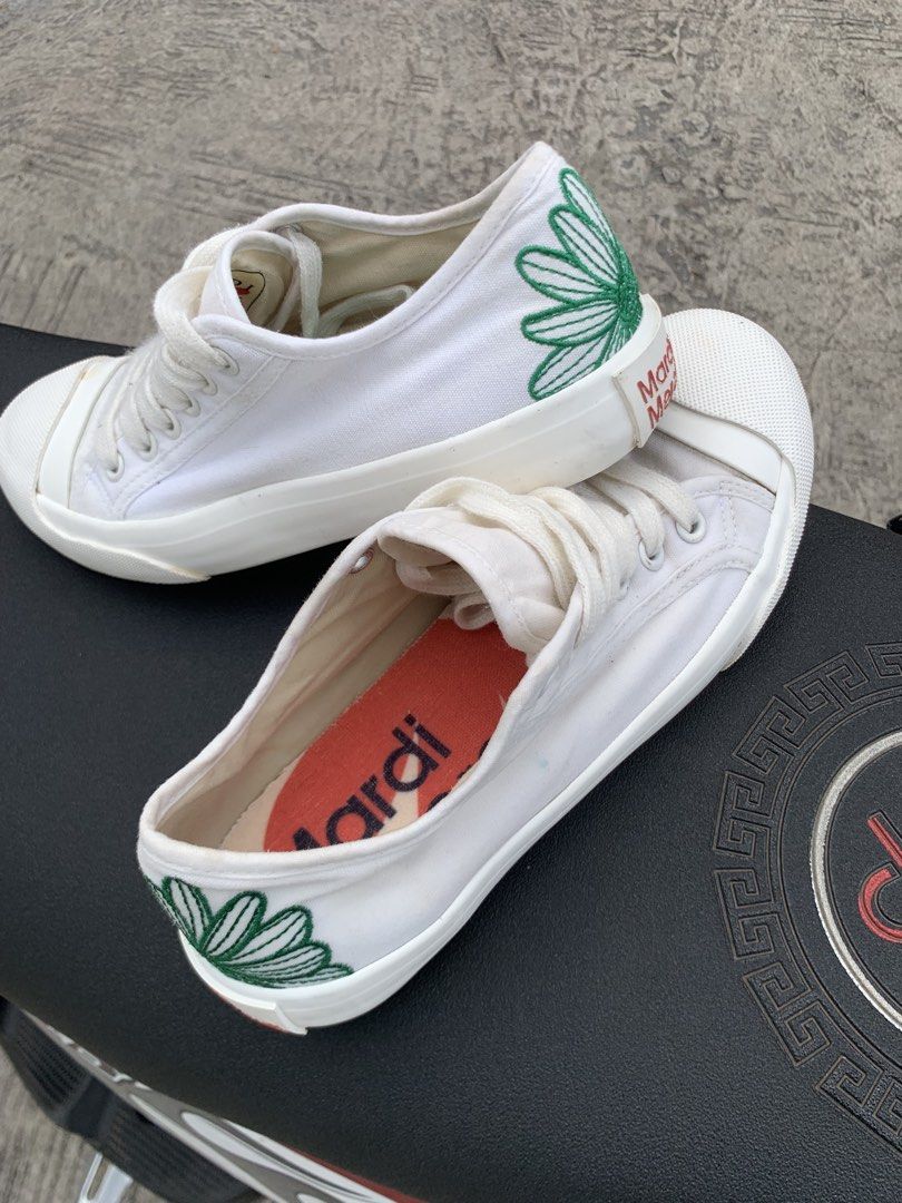 Mardi Mercredi White Sneakers (Category: Sneakers) located in Polomolok. Submitted by domingthriftclothes (Listing ID 1436532455, Image 2). Description: - Mardi Mercredi white sneakers - Green daisy design on the side - Brand name on the heel - Brand name printed on the insole - White laces - White rubber toe cap.