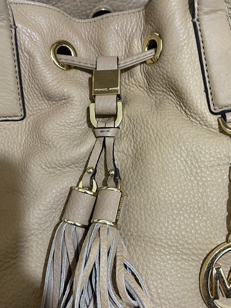 Michael Kors Tan Leather Handbag (Category: Luxury Bags & Wallets) located in Manila. Submitted by marisol1218.581 (Listing ID 1436635111, Image 2). Description: - Authentic Michael Kors handbag - Tan leather - Drawstring closure - Gold-tone hardware - Detachable shoulder strap - MK logo charm with tassel - Top handle - Chain strap.