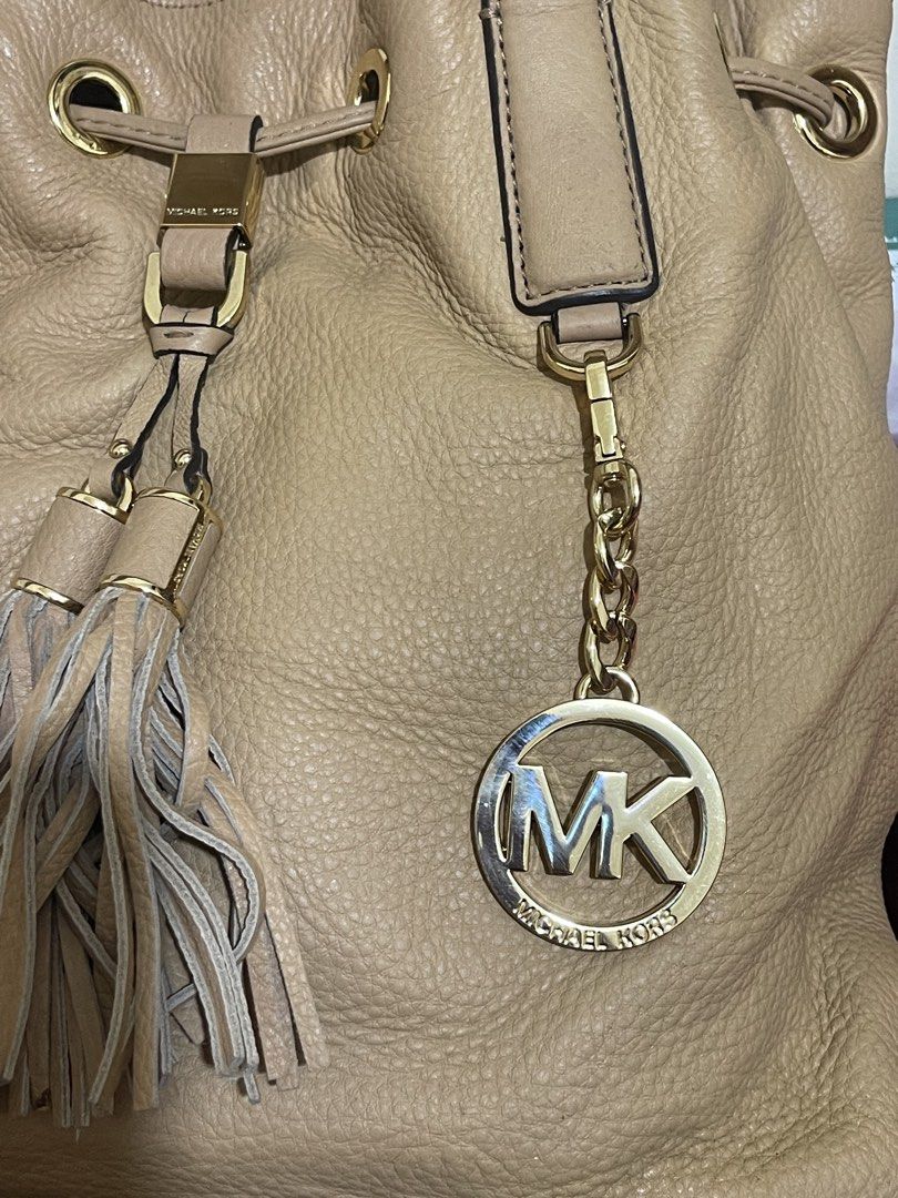Michael Kors Tan Leather Handbag (Category: Luxury Bags & Wallets) located in Manila. Submitted by marisol1218.581 (Listing ID 1436635111, Image 3). Description: - Authentic Michael Kors handbag - Tan leather - Drawstring closure - Gold-tone hardware - Detachable shoulder strap - MK logo charm with tassel - Top handle - Chain strap.