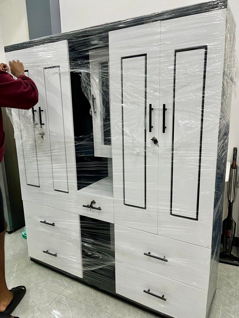 Modern White and Black Wardrobe with Mirror (Category: Shelves, Cabinets & Racks) located in Bulacan. Submitted by sssaaayyy (Listing ID 1436486185, Image 3). Description: Modern 4-Door Wardrobe Cabinet Black & White Edition Dimensions: Width — 152 cm (60”) Depth — 41 cm (16”) Height — 183 cm (72”) Includes: • Wardrobe cabinet with 4 full-length doors and black bar handles • Vanity and chair • 2 hanging rod sections • Center shelves with lockable