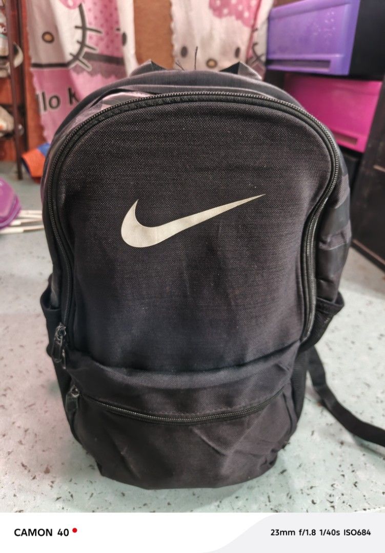 Nike Backpack (Category: Backpacks) located in San Carlos City. Submitted by dhong_abay_thrift (Listing ID 1436498233, Image 1). Description: - Black Nike backpack - White Nike logo - Main compartment - Front pocket - Side pockets - Adjustable shoulder straps - Durable fabric - Visible zippers.