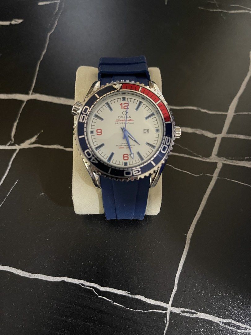 Omega Seamaster Diver 300m Watch (Category: Luxury Watches) located in Manila. Submitted by mrallout (Listing ID 1436489734, Image 1). Description: Omega Seamaster Diver 300m watch with a blue rubber strap. Features a white dial with red accents and a date display. The watch has a stainless steel case and a blue bezel. The back of the watch shows the Omega logo and other details. - The watch is on brand new condition - No box - Extra pair Pasig l