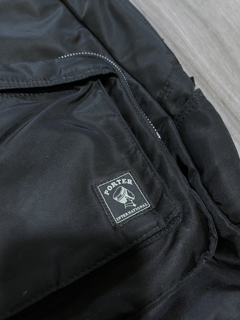 Porter International Black Backpack (Category: Backpacks) located in Manila. Submitted by calmocean-f675cc (Listing ID 1436537983, Image 2). Description: - Black Porter International backpack - Front pocket with Porter logo - Main compartment with zipper closure - Orange interior lining - Adjustable straps - Unique zipper pull design - Made of a nylon-like material.