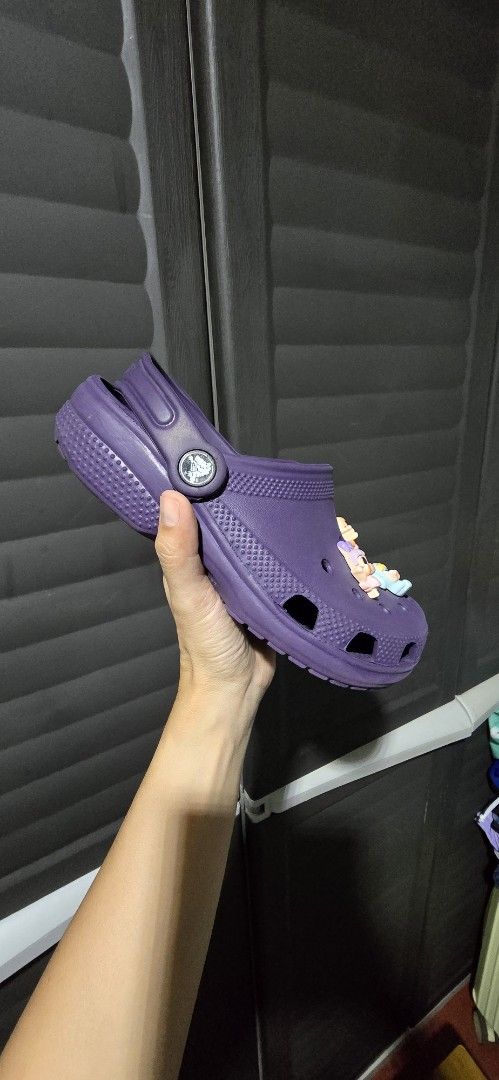 Purple Crocs with Jibbitz (Category: Slippers and slides) located in Manila. Submitted by muliph (Listing ID 1436477395, Image 3). Description: - Size J2 - Purple Crocs with Jibbitz. - Classic clog design. - Features ventilation holes for charm customization. - Includes various cartoon character charms. - Soles show some wear..
