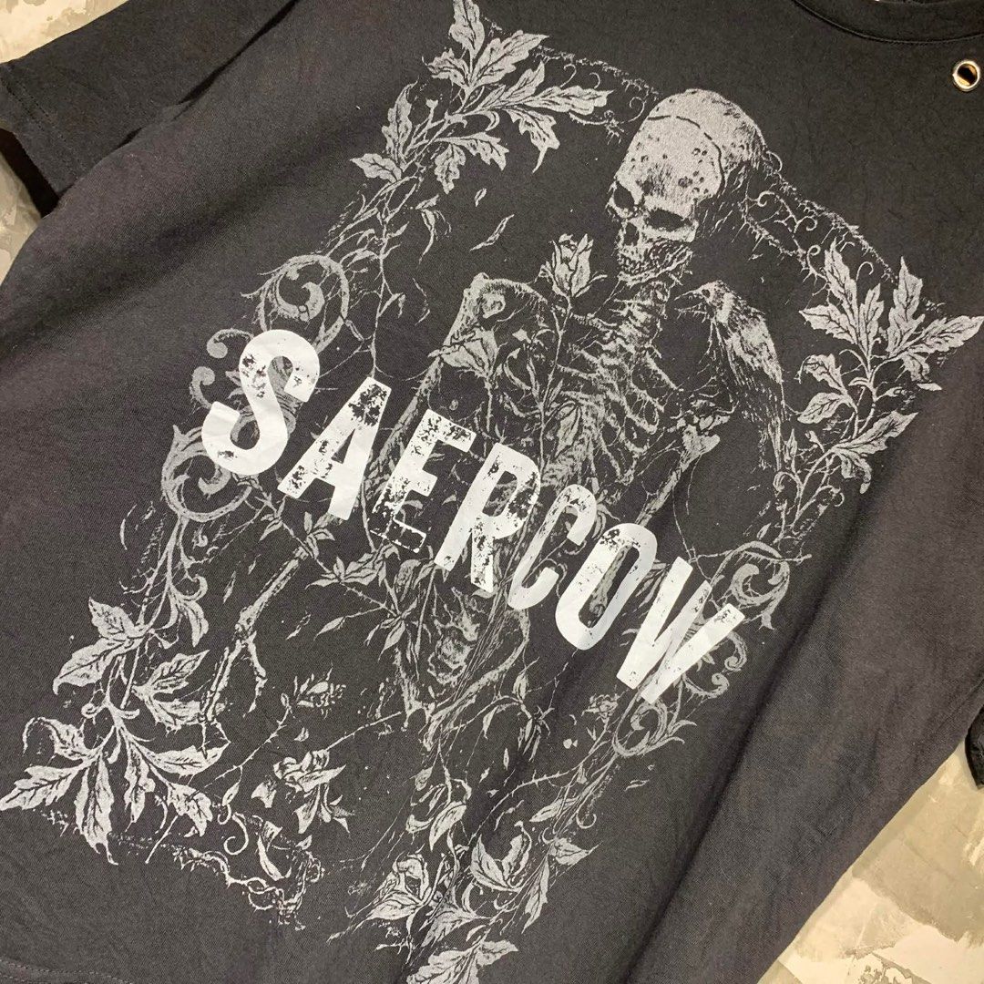 Saercow Skeleton Graphic T-shirt (Category: Tshirts & Polo Shirts ) located in Manila. Submitted by notjustfits (Listing ID 1436642321, Image 2). Description: SAERCOW ◾ Dimes: 23×28 ◾ Condition: Excellent condition ◾ Flaw/s: no issue - Black Saercow T-shirt - Features a skeleton graphic - Crew neck design - Includes metal eyelets - Made of 100% cotton - Brand label is visible - Size not indicated.