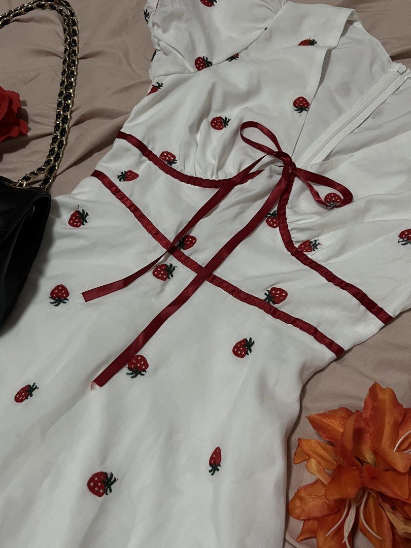 Strawberry Embroidered Dress (Category: Dresses) located in Manila. Submitted by declutterwithandi.148 (Listing ID 1436525144, Image 2). Description: - White dress with adorable strawberry embroidery - Flattering V-neckline - Cute short puff sleeves - Fitted waist for a great silhouette - Charming red ribbon detail at bust and waist - Flowing, flared skirt - Perfect for warm weather with its lightweight fabric.