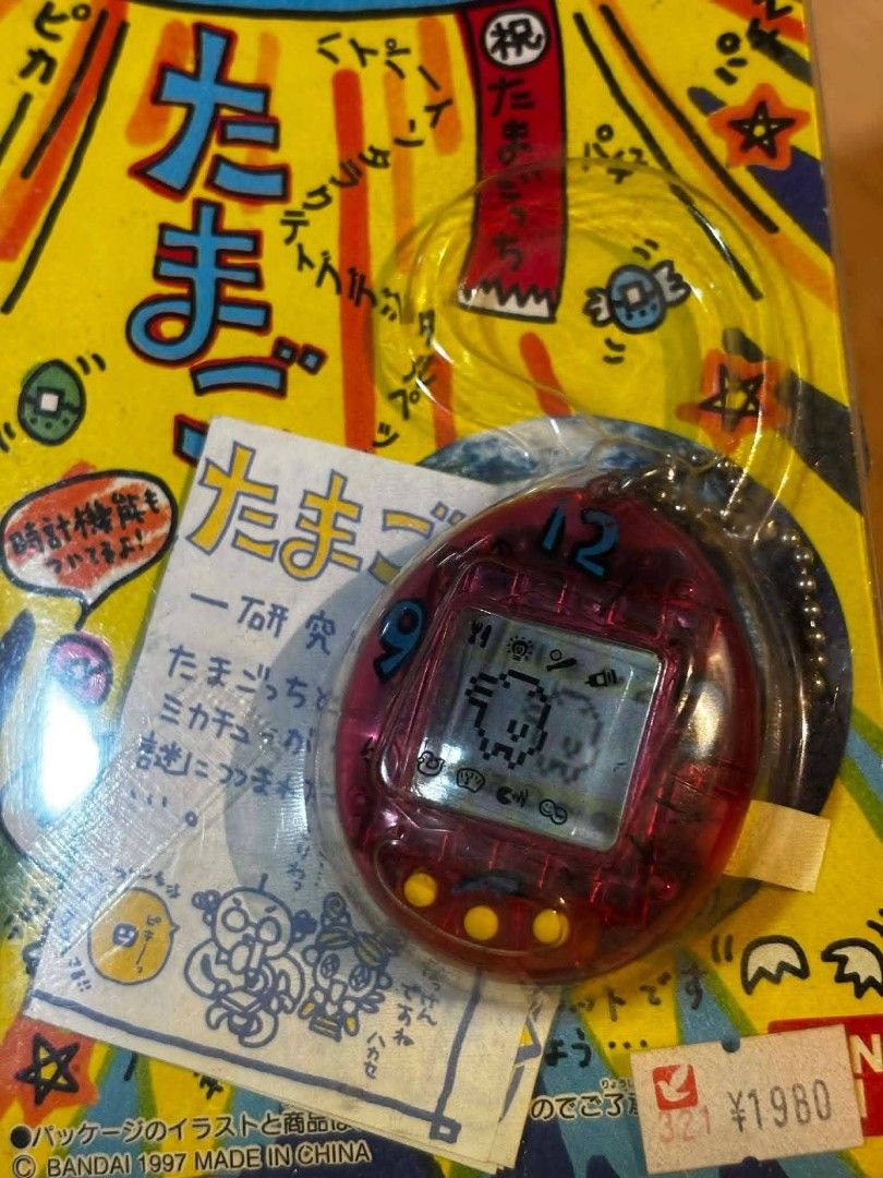 Tamagotchi Virtual Pet (Category: Interactive Toys) located in Valenzuela. Submitted by upcycle_things (Listing ID 1436517596, Image 2). Description: Vintage Tamagotchi virtual pet, still sealed in its original packaging. Features a red Tamagotchi with a digital display. Includes original packaging with Japanese text and a ¥1980 price tag..