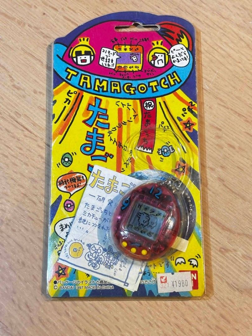 Tamagotchi Virtual Pet (Category: Interactive Toys) located in Valenzuela. Submitted by upcycle_things (Listing ID 1436517596, Image 3). Description: Vintage Tamagotchi virtual pet, still sealed in its original packaging. Features a red Tamagotchi with a digital display. Includes original packaging with Japanese text and a ¥1980 price tag..