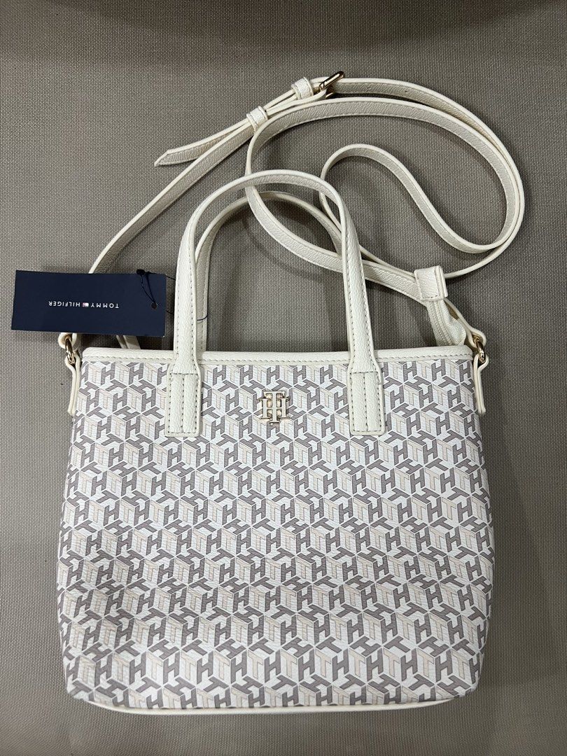Tommy Hilfiger Monogram Crossbody Bag (Category: Cross-body Bags) located in Quezon City. Submitted by janellemariano (Listing ID 1436568864, Image 1). Description: - Tommy Hilfiger sling bag - White and gray monogram pattern - Top handle and detachable sling strap - Interior small pocket - Zipper closure - Gold-tone hardware - Includes original tag.