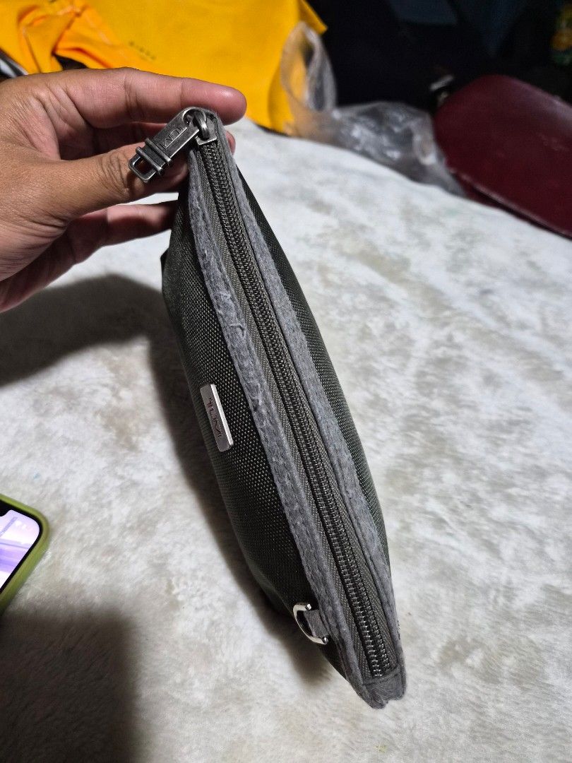 Tumi Amenity Pouch (Category: Headphones & Headsets) located in Mandaue City. Submitted by chuchi152615 (Listing ID 1436503981, Image 3). Description: - Authentic Tumi pouch - Color: Dark Green - Secure zipper closure - Includes a small metal loop - Features the iconic Tumi logo - Constructed from a durable, textured material.
