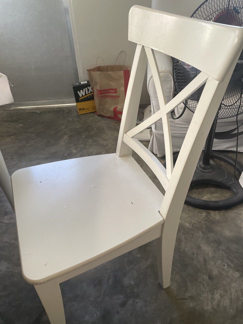 White Wooden Dining Chair (Category: Chairs) located in Santa Rosa. Submitted by emelyn71 (Listing ID 1436472492, Image 1). Description: - White wooden dining chair - Features an X-shaped back design - Square seat - Curved backrest - Minor marks present - Painted white.