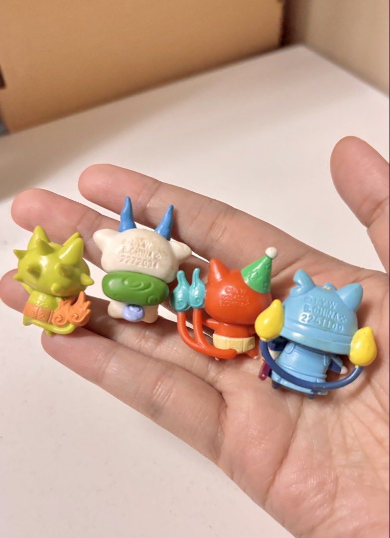 Yo-kai Watch Figurines take all set (Category: Fan Merchandise) located in Pasay City. Submitted by tindeclutterstuff (Listing ID 1436565143, Image 3). Description: Set of four Yo-kai Watch figurines. The figurines feature different characters with unique designs and colors. They appear to be made of plastic and are small in size. One figurine is on a small bench. The set includes a coin for size comparison. #yokai.