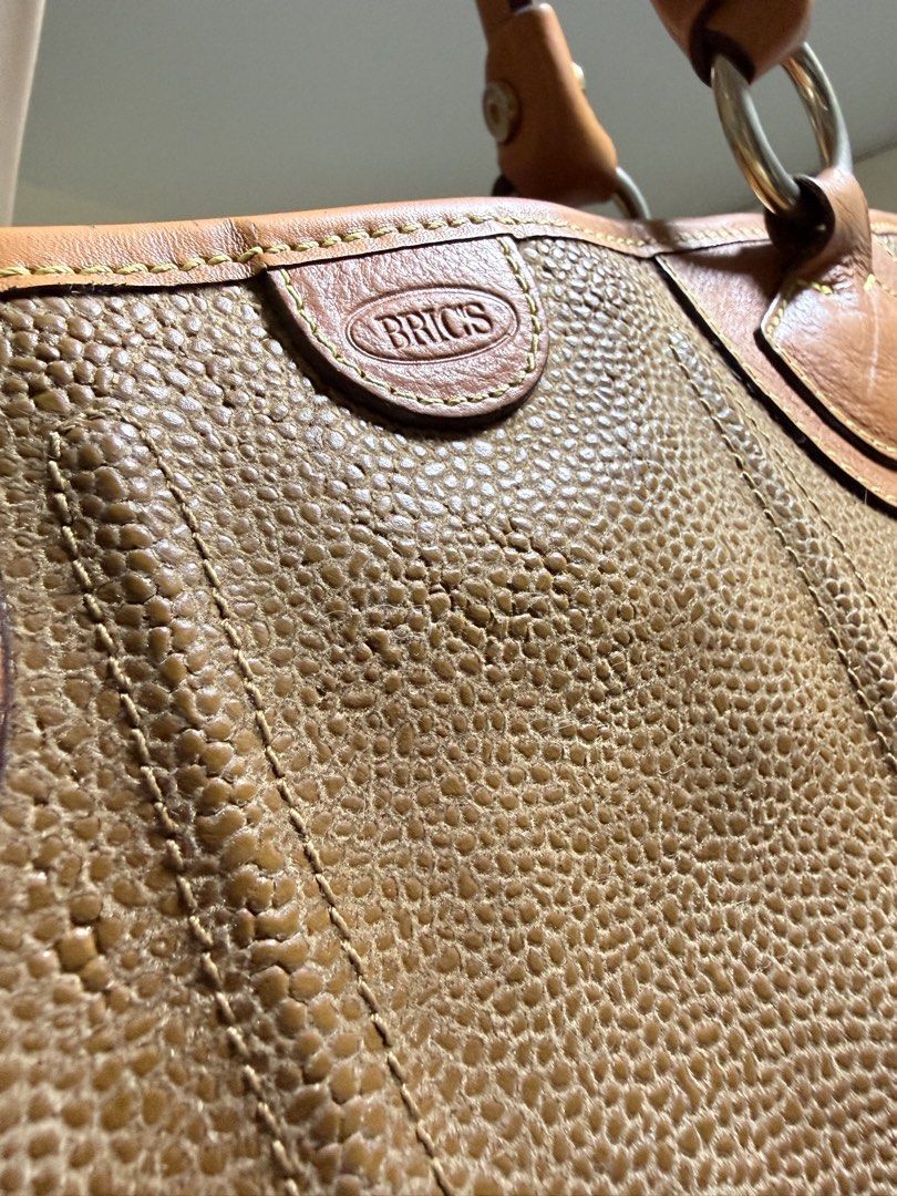 Authentic BRIC'S Tote Bag (Category: Tote Bags) located in Cavite. Submitted by lady_speculator_ph (Listing ID 1436821518, Image 3). Description: - Authentic BRIC'S tote bag in brown - Textured exterior - Genuine leather accents and handles - Fabric lined interior - Small interior pocket - Secure zipper closure - Brand logo visible - Hardware have fading, but still looks polished.