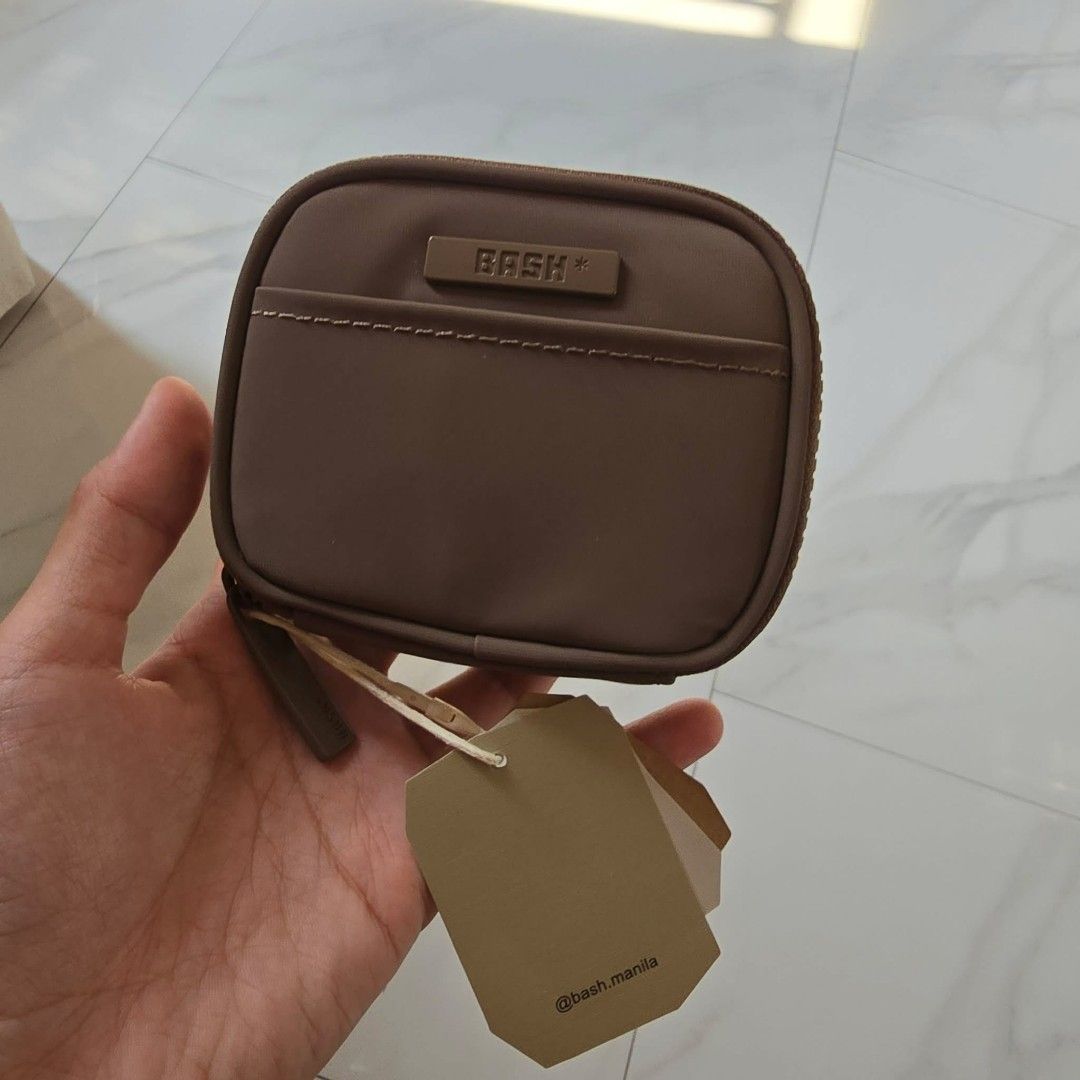 BASH Manila Square Wallet (Category: Wallets & Card holders) located in Taguig. Submitted by thriftzzzy (Listing ID 1436800623, Image 1). Description: - BASH Manila square wallet - Features a zip closure - Includes a small front pocket - Interior has a small compartment - Available colors: Brown and Black - Comes with original tag.