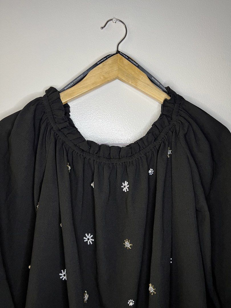 Black Off-Shoulder Blouse with Beaded Snowflake Details (Category: Blouses) located in Quezon City. Submitted by pcera (Listing ID 1436785847, Image 2). Description: - Black off-shoulder blouse - Long sleeves with ruffled cuffs - Ruffled neckline - Delicate snowflake embellishments - Flowy, relaxed fit - Perfect for casual and semi-formal events.
